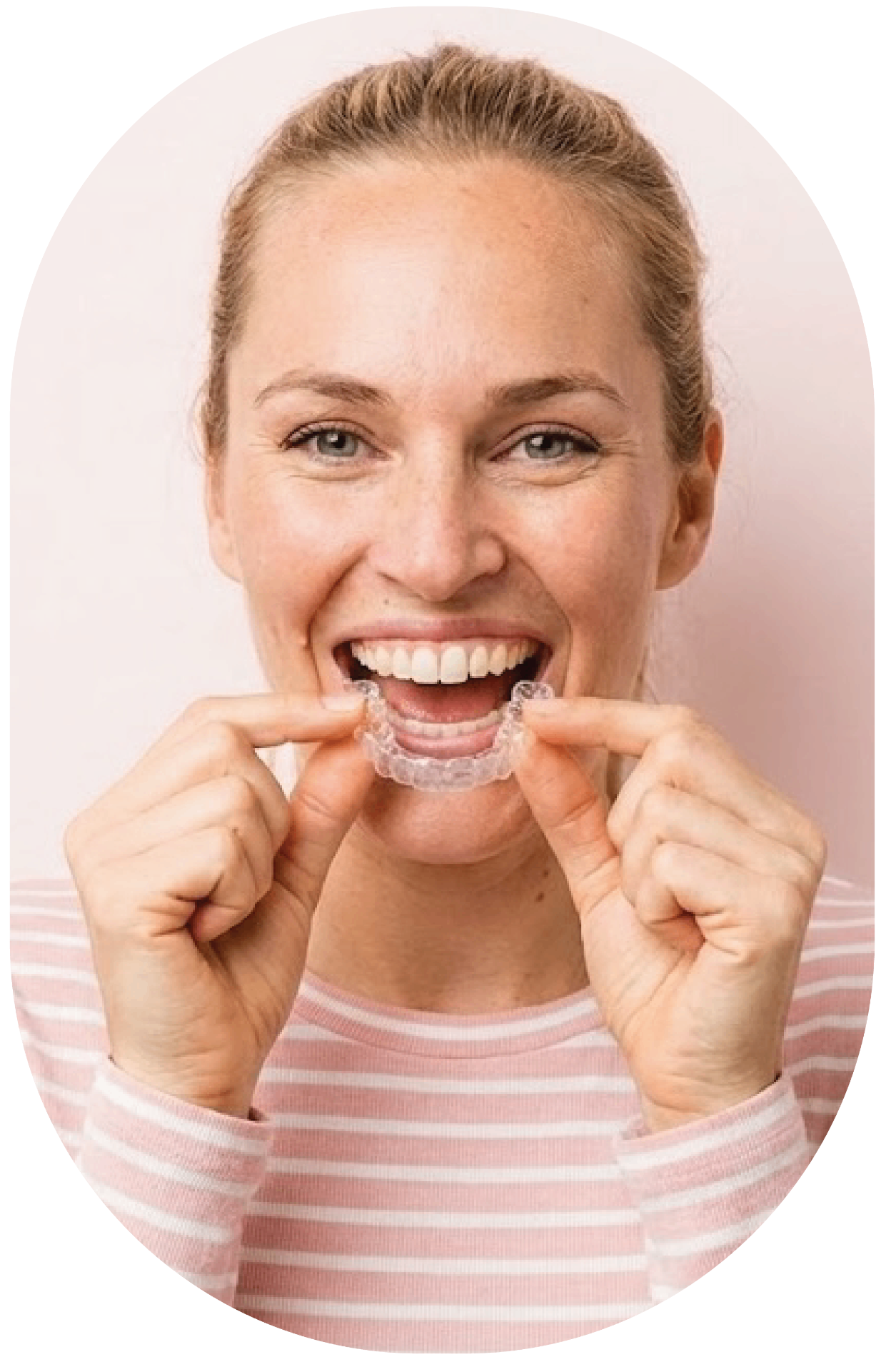Smiling woman holding clear aligner tray